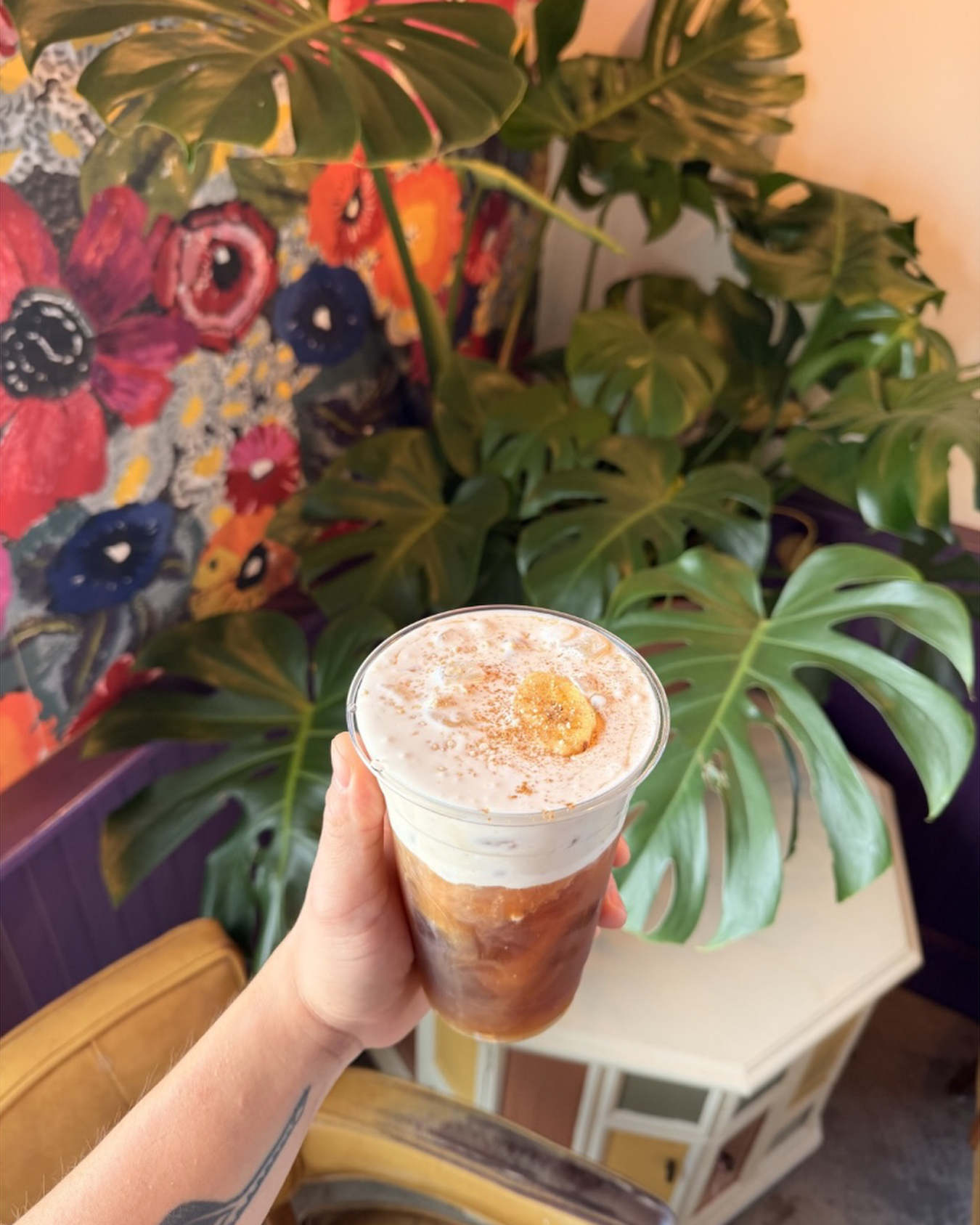 Iced banana latte topped with cinnamon and a banana slice