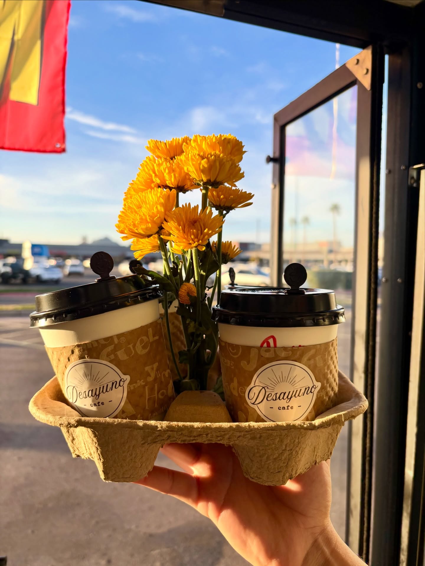Coffees to go with fresh marigolds at the window