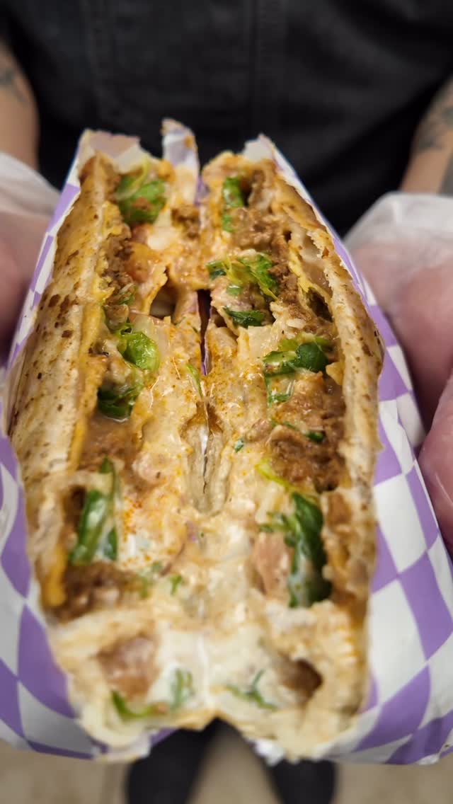 Crunch God Supreme handheld cut in half, showing chorizo, beans, lettuce and jalapeno cream cheese